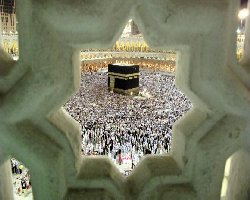 Inner Dimension of Hajj A view of the Ka'bah surrounded by a large crowd of pilgrims, framed by an ornamental structure.